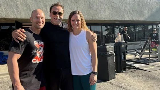 Jeremi Dierenfeldt (left) and his wife Danielle (right), pose for a photo with Actor and Bodybuilder Arnold Schwarzenegger (middle).