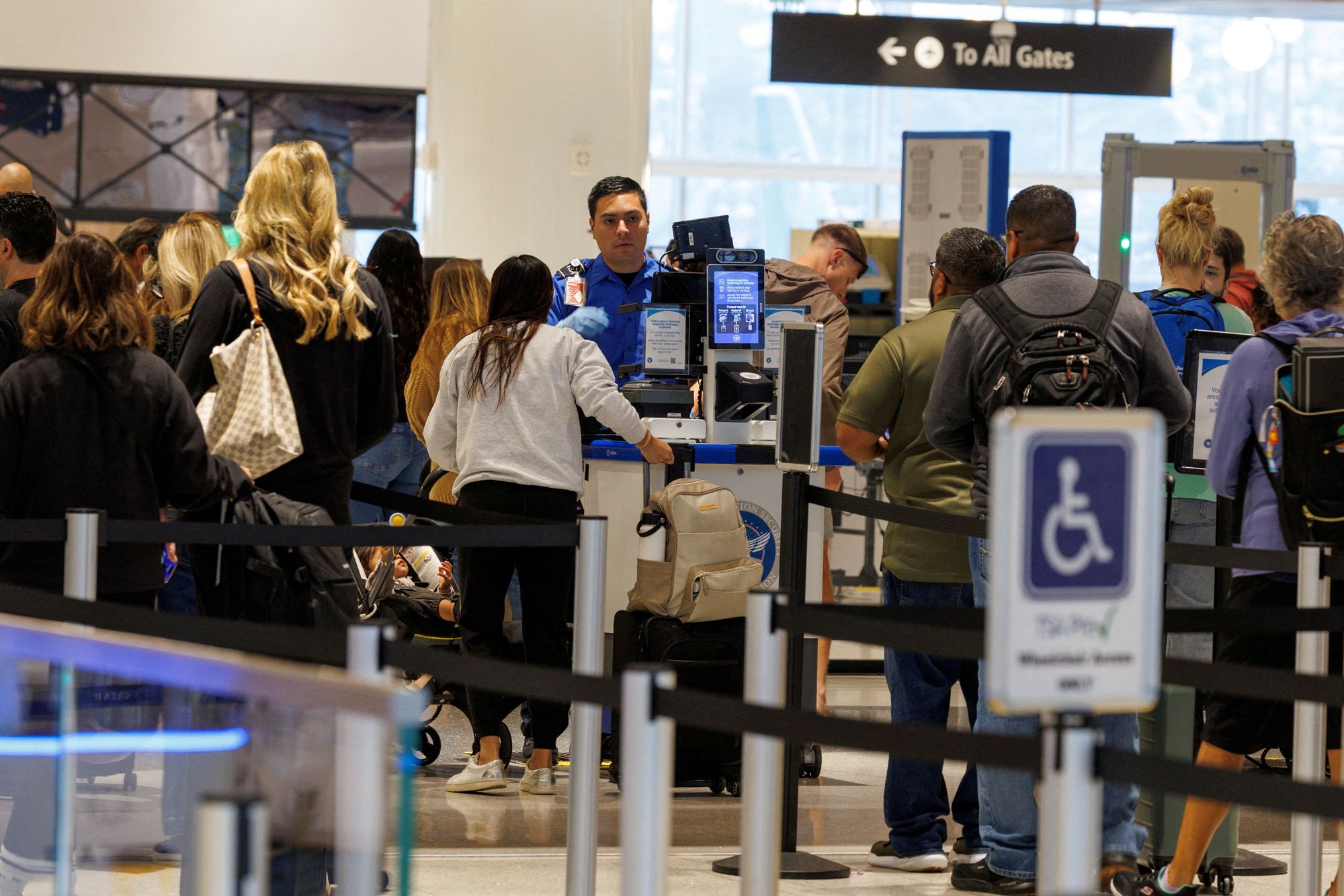 <i>Mike Blake/Reuters via CNN Newsource</i><br/>A TSA agent checks travelers at San Diego International Airport during the 2025 government shutdown in San Diego