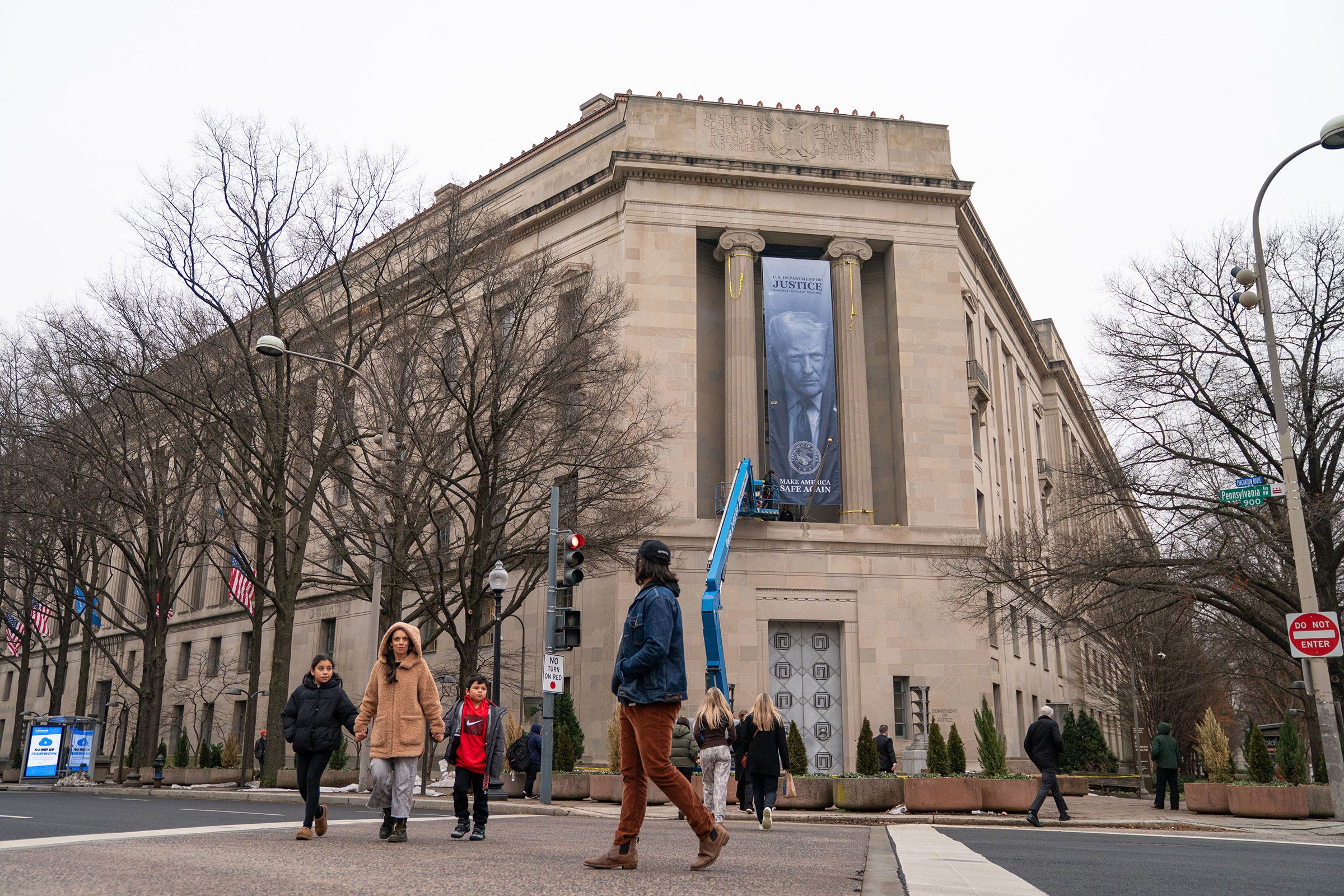 <i>Allison Robbert/AP via CNN Newsource</i><br/>A banner showing President Donald Trump is hung from the Department of Justice