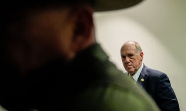 People walk by signs memorializing Renee Good and Alex Pretti on February 12