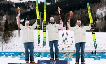 Gold medalist Johannes Hoesflot Klaebo of Norway celebrates on the podium after the men's 50km mass start classic alongside silver medalist Martin Loewstroem Nyenget of Norway and bronze medalist Emil Iversen of Norway