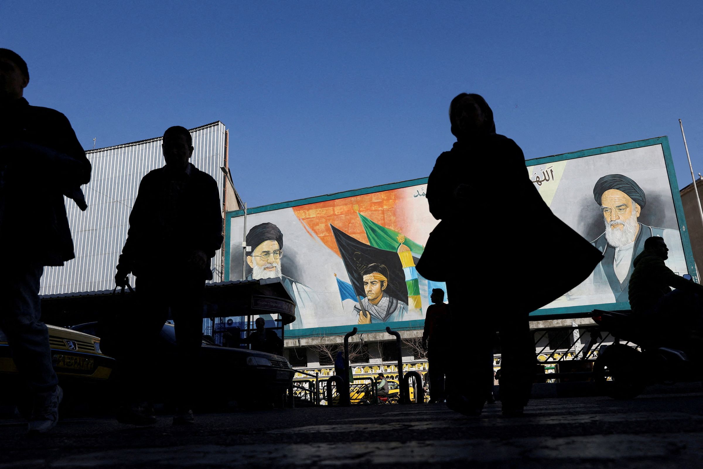 <i>Majid Asgaripour/Wana News Agency/Reuters via CNN Newsource</i><br/>People walk near a mural featuring images of Iran's Supreme Leader Ayatollah Ali Khamenei and leader of Iran's 1979 Islamic Revolution Ayatollah Ruhollah Khomeini