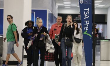 Travelers walk past a TSA PreCheck entry spot at the Miami International Airport as some of the year's busiest travel days occur during the holiday season in Miami