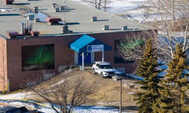 A police vehicle is parked in front of Tumbler Ridge Secondary School where a mass shooting took place on Tuesday.