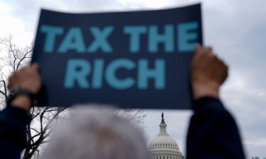 A demonstrator holds a "Tax The Rich" sign during a protest near the Capitol in Washington
