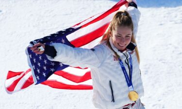 Shiffrin sits on the side of the course after skiing out in the first run of the women's slalom at the 2022 Winter Olympics.