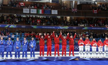 Curlers stand on the podium with their medals