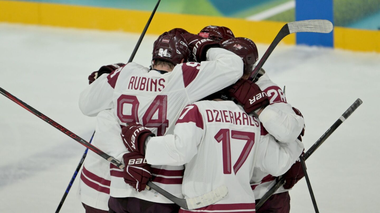 Latvia's men's hockey team celebrates during an Olympic group stage win over Germany.