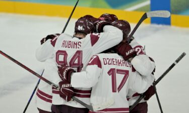 Latvia's men's hockey team celebrates during an Olympic group stage win over Germany.