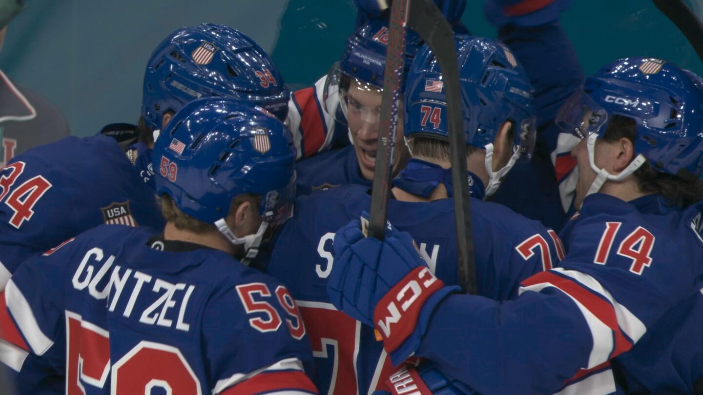 U.S. men's hockey players celebrate with Matt Boldy after he scores against Denmark in Olympic hockey.