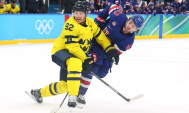 U.S. men's hockey player Quinn Hughes shoots and scores during a quarterfinal overtime win over Sweden at the Olympics.
