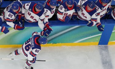 U.S. men's hockey player Jack Hughes high fives the bench after scoring over Slovakia in the Olympic semifinal round.