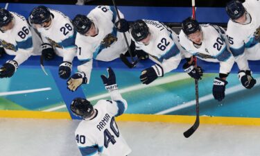 Finland men's hockey player Joel Armia high fives his bench after scoring in the bronze medal game at the 2026 Milan Cortina Olympics.