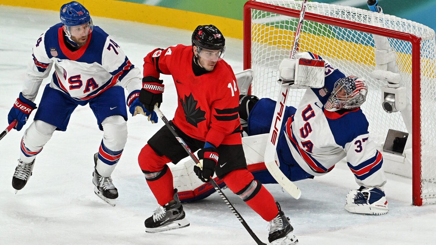 <i>NBC Olympics</i><br/>Connor Hellebuyck defends the goal against a Canadian player