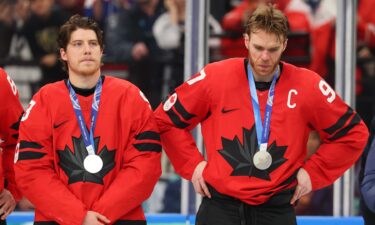Canadian players look on with silver medals around their necks.