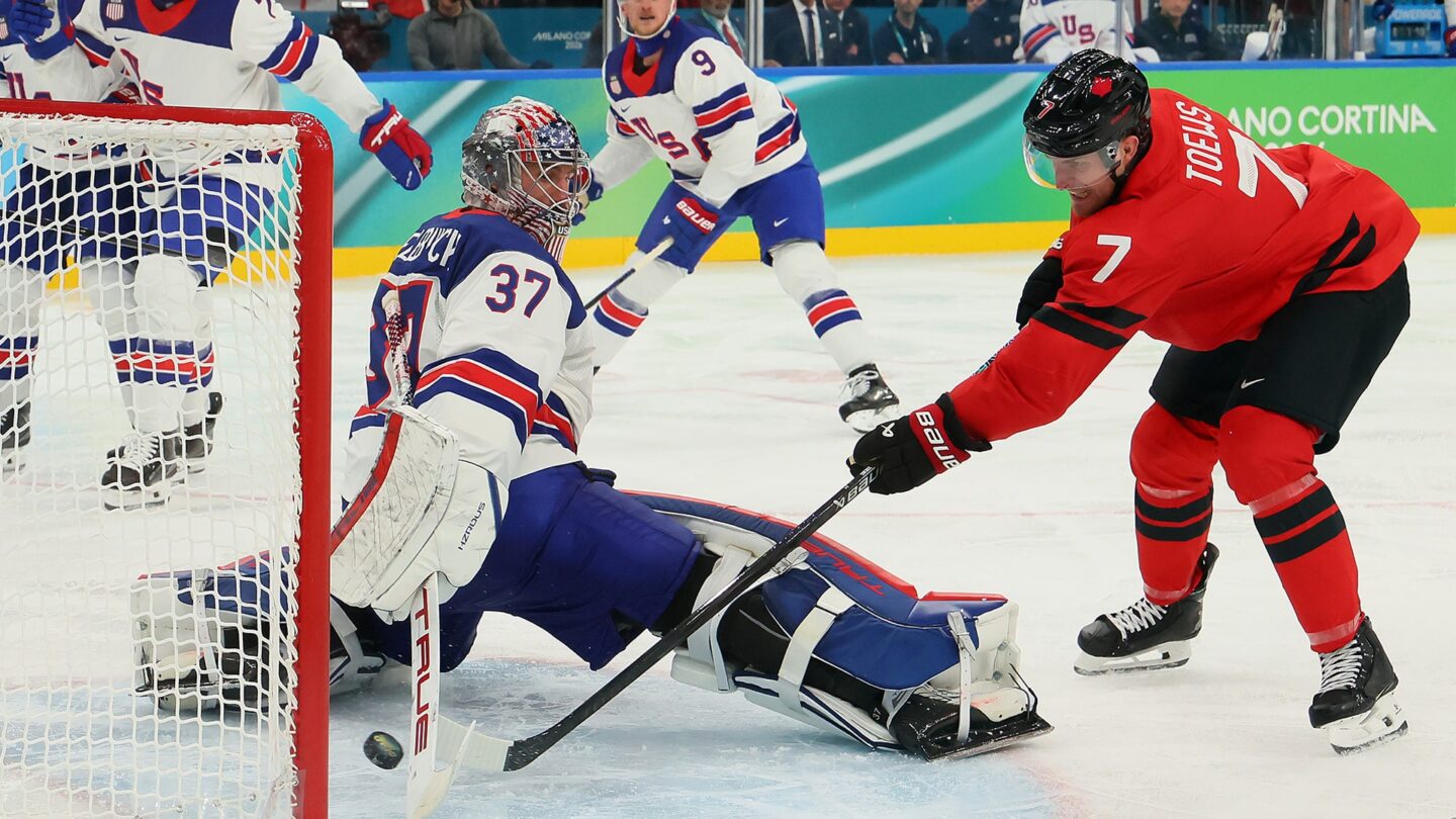 <i>NBC Olympics</i><br/>Connor Hellebuyck stops a shot from a Canadian men's hockey player.