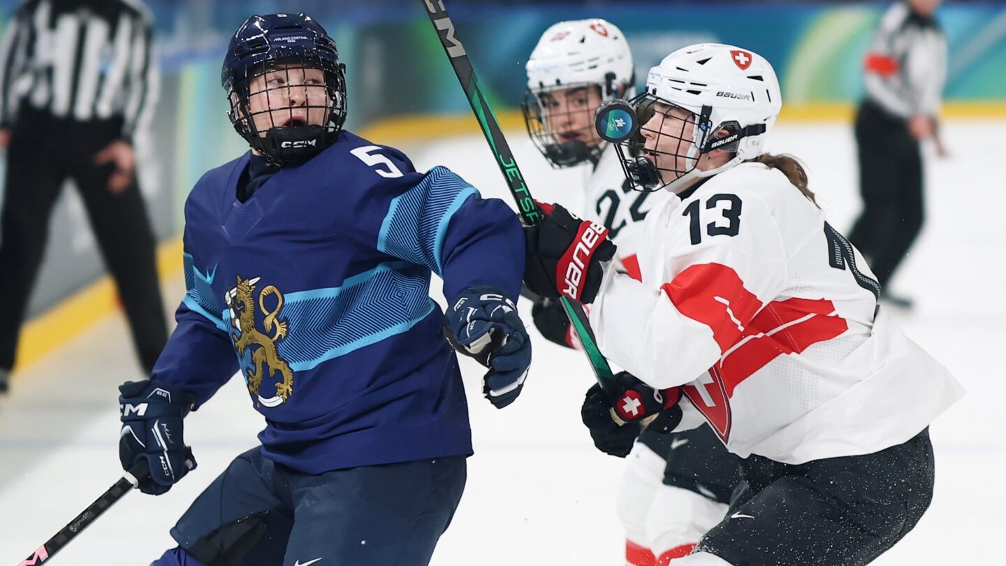 Switzerland women's hockey players Ivana Wey and Sinja Leemann go up against Siiri Yrjola of Finland at the 2026 Olympics.