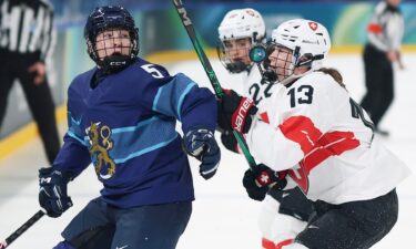 Switzerland women's hockey players Ivana Wey and Sinja Leemann go up against Siiri Yrjola of Finland at the 2026 Olympics.