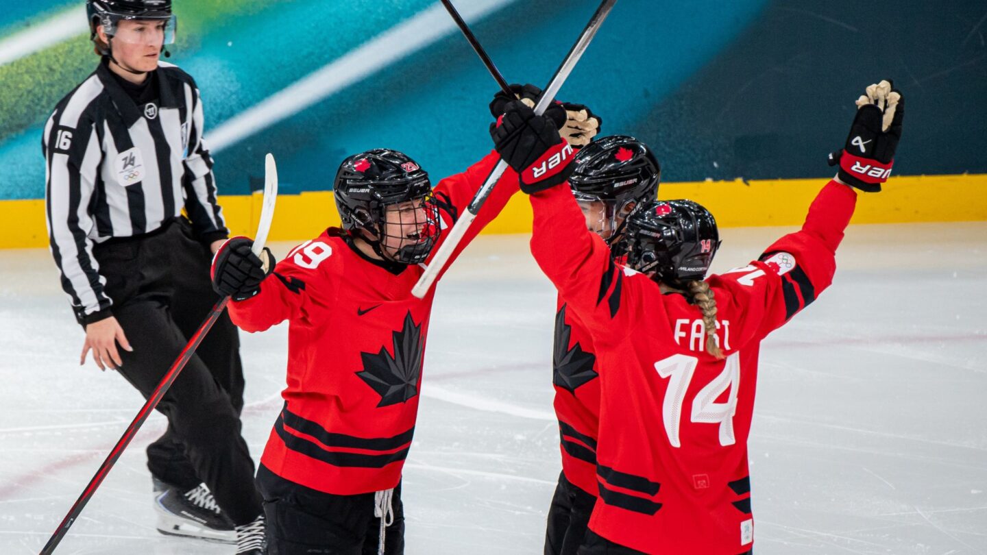 Canadian captain Marie-Philip Poulin celebrates with teammates Sophie Jaques and Renata Fast during a semifinal matchup with Switzerland at the 2026 Olympics.