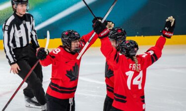 Canadian captain Marie-Philip Poulin celebrates with teammates Sophie Jaques and Renata Fast during a semifinal matchup with Switzerland at the 2026 Olympics.