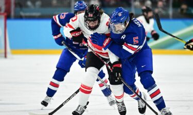 U.S. women's hockey player Megan Keller fights for the puck on the ice against Canada in the gold medal game at the 2026 Olympics.