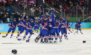 The U.S. women's hockey team celebrates on the ice after beating Canada in overtime for gold at the 2026 Milan Cortina Olympics.