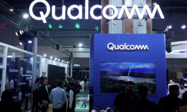 Visitors stand at the Qualcomm kiosk at Bharat Mandapam