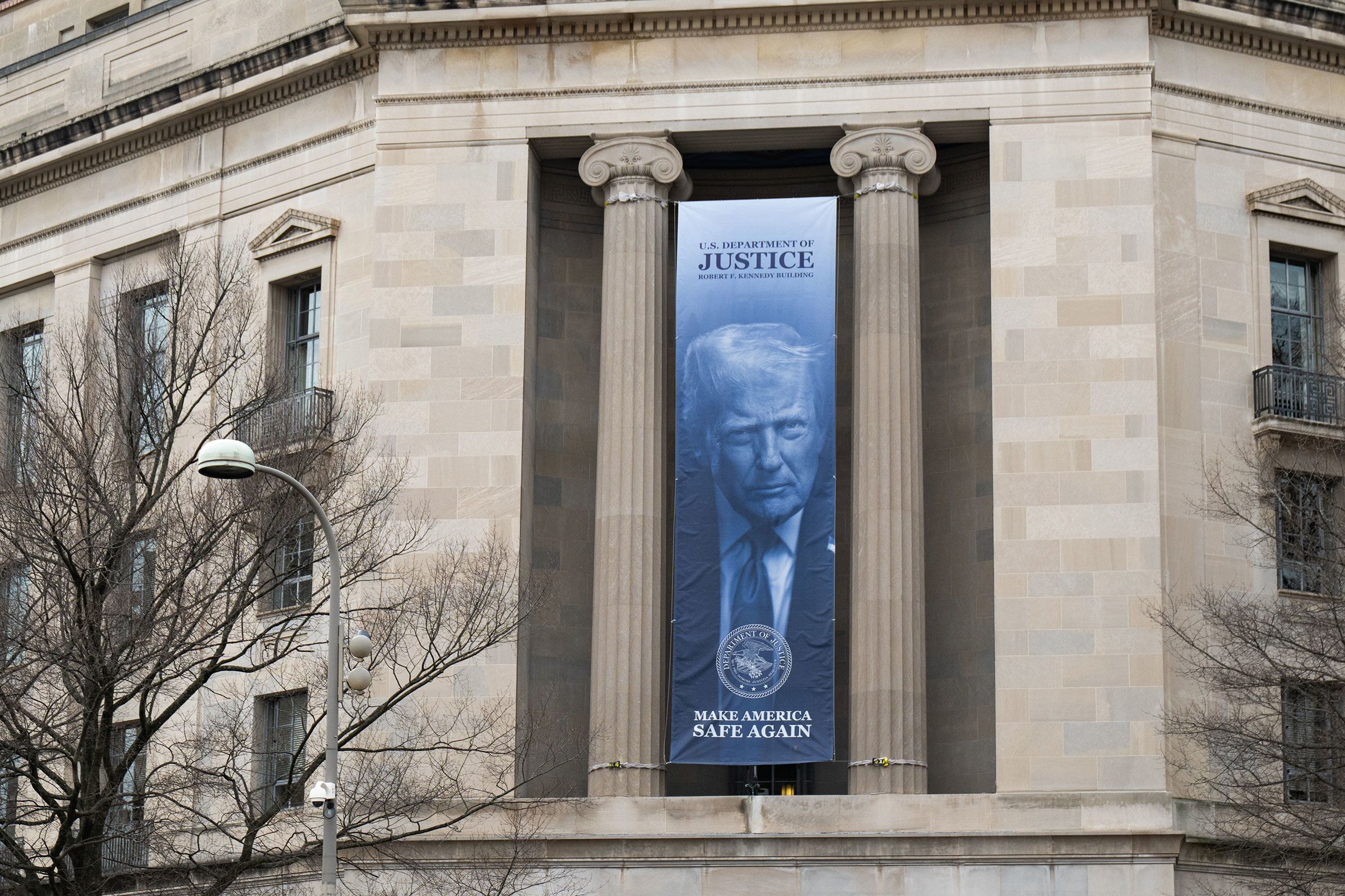 <i>Annabelle Gordon/Sipa USA/AP/File via CNN Newsource</i><br/>A banner of President Trump hangs from the Department of Justice building in Washington