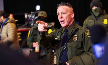 Federal agents gather next to a damaged vehicle after its driver