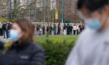 Students line up for antibiotics outside a building at the University of Kent in Canterbury