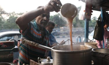 A worker loads depleted liquefied petroleum gas (LPG) canisters onto a truck at a depot in New Delhi