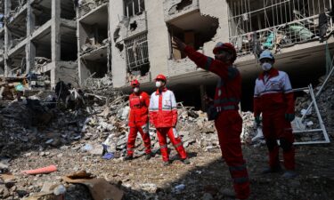 Members of a Red Crescent rescue team work at a building that was damaged by a strike