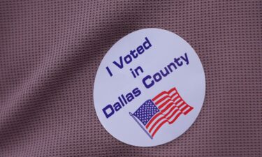 A primary voter wears a sticker after casting a ballot at a voting center in Dallas