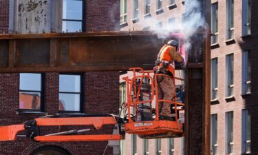 A construction worker welds a beam at a building under construction
