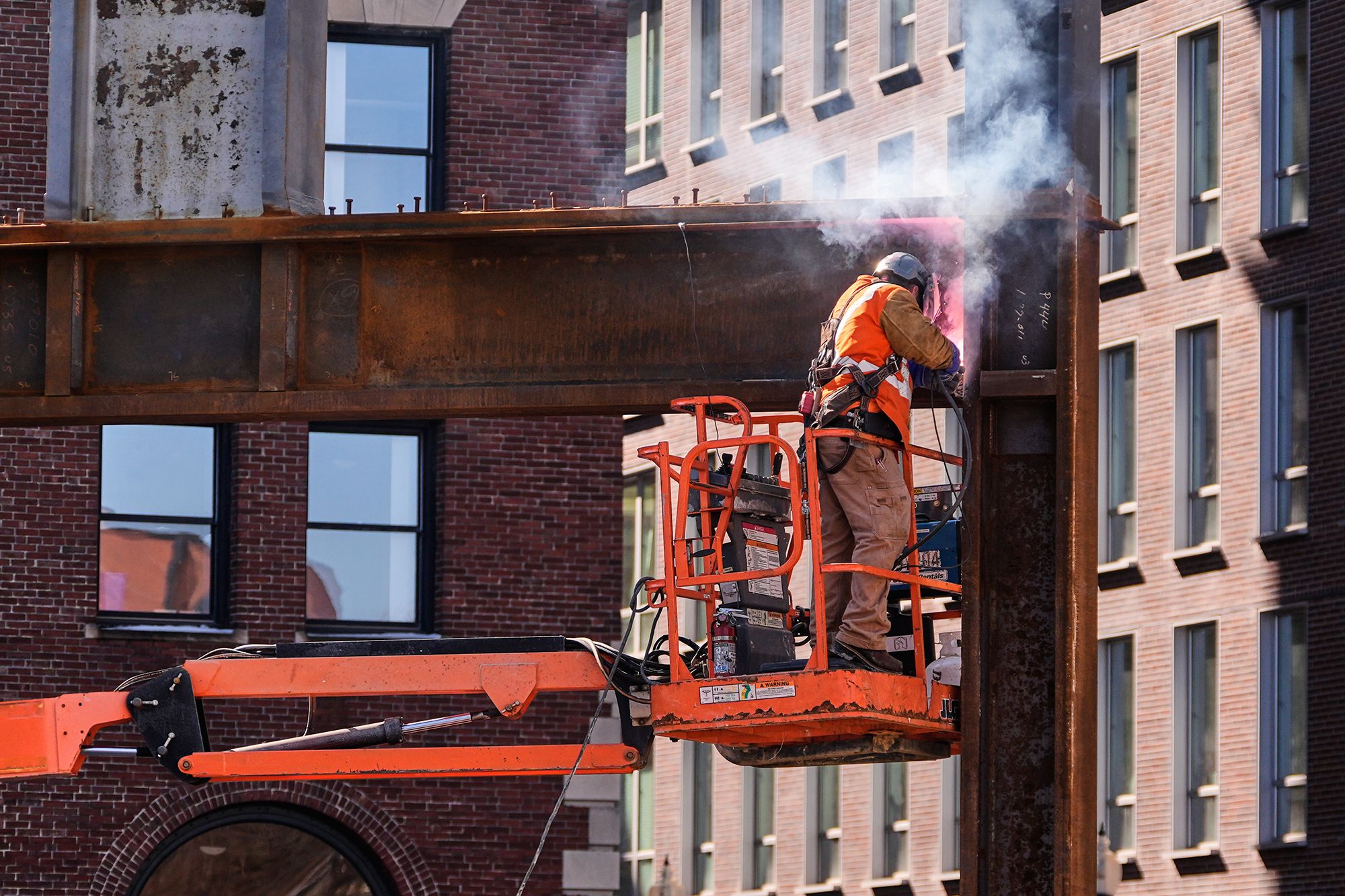 <i>Charles Krupa/AP via CNN Newsource</i><br/>A construction worker welds a beam at a building under construction
