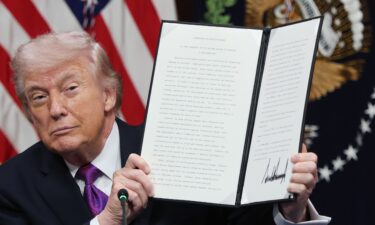 President Donald Trump holds up the Ratepayer Protection Pledge after signing it during a roundtable meeting in the Indian Treaty Room at the White House on March 4.