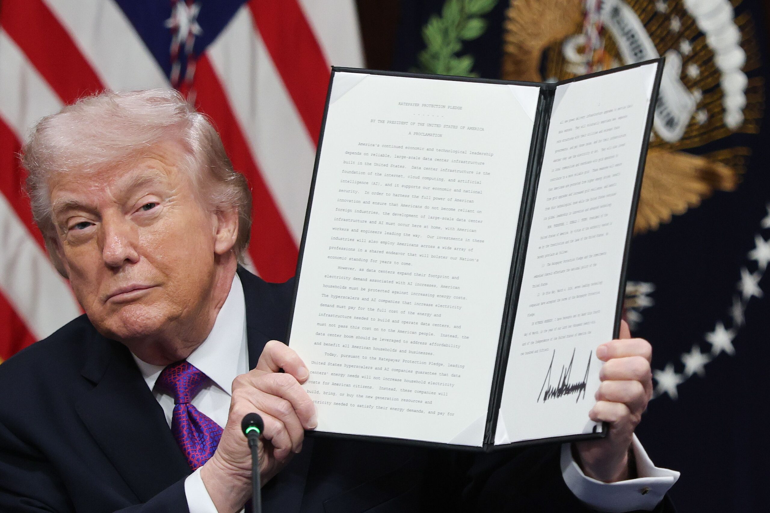 <i>Win McNamee/Getty Images via CNN Newsource</i><br/>President Donald Trump holds up the Ratepayer Protection Pledge after signing it during a roundtable meeting in the Indian Treaty Room at the White House on March 4.