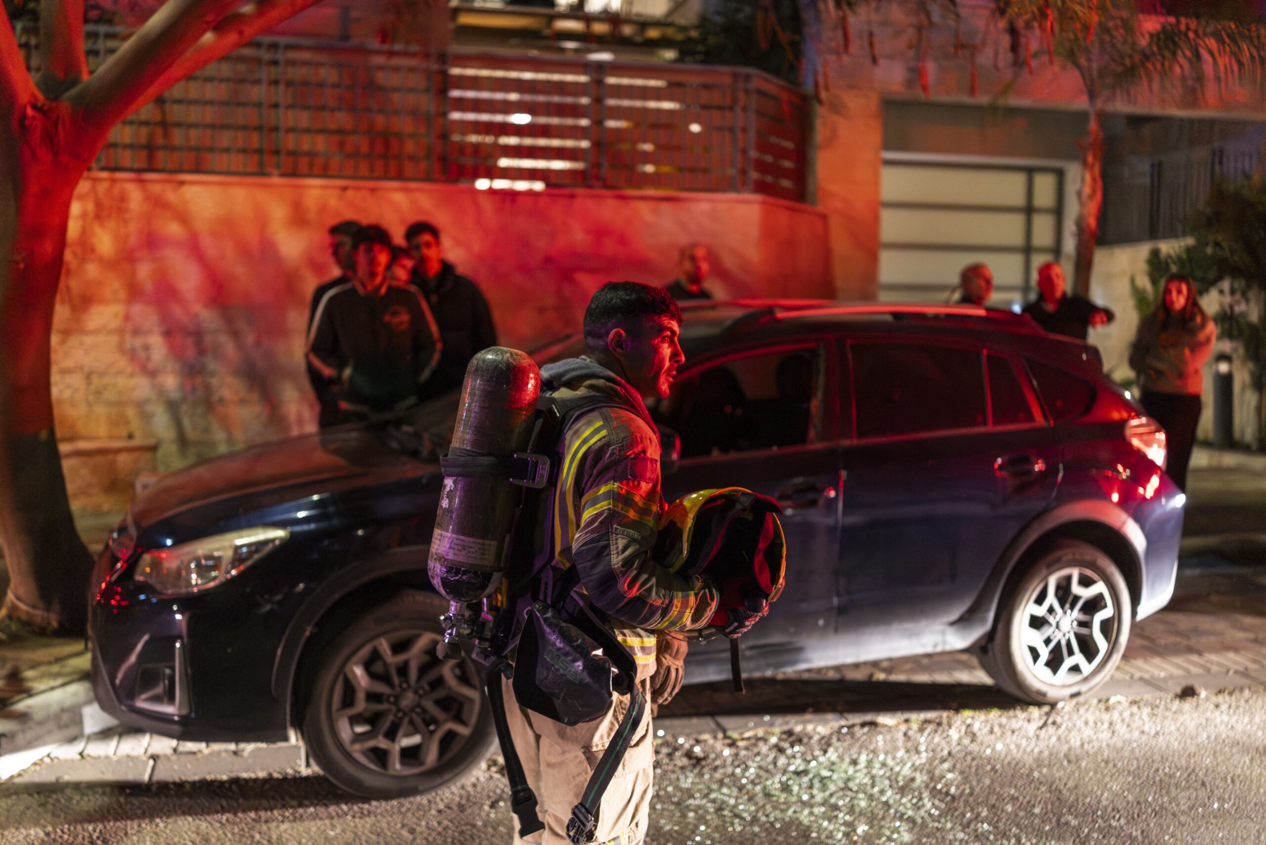 <i>Ilia YefiMovich/AFP/Getty Images via CNN Newsource</i><br/>A firefighter holds a helmet as he operates outside a building hit by a projectile in a city in outskirts of Tel-Aviv