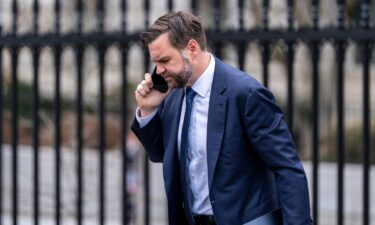 People watch as smoke rises on the skyline after an explosion in Tehran
