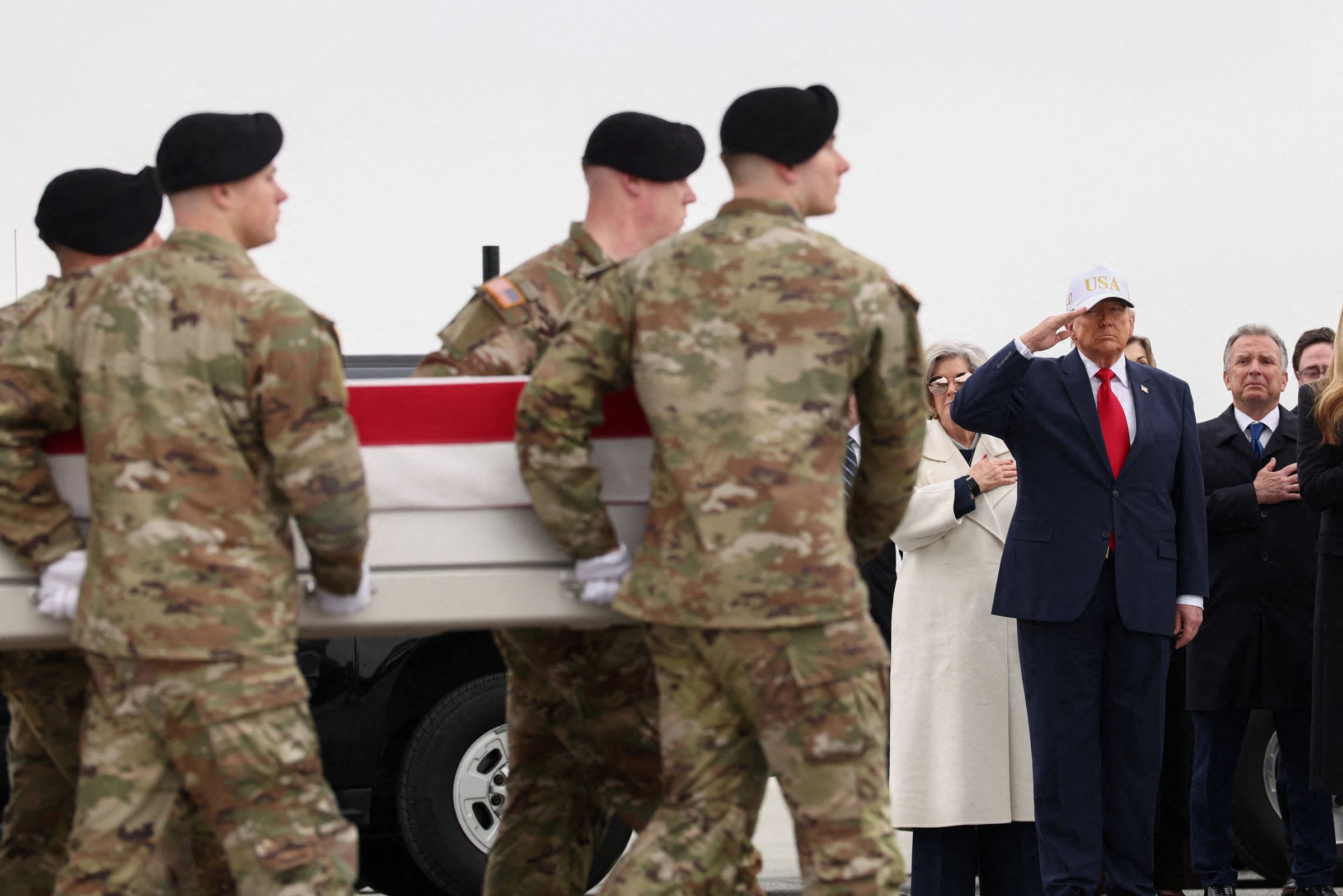 <i>Kevin Lamarque/Reuters via CNN Newsource</i><br/>President Donald Trump stands as members of military carry a transfer case during a dignified transfer of the remains of six U.S. Army service members
