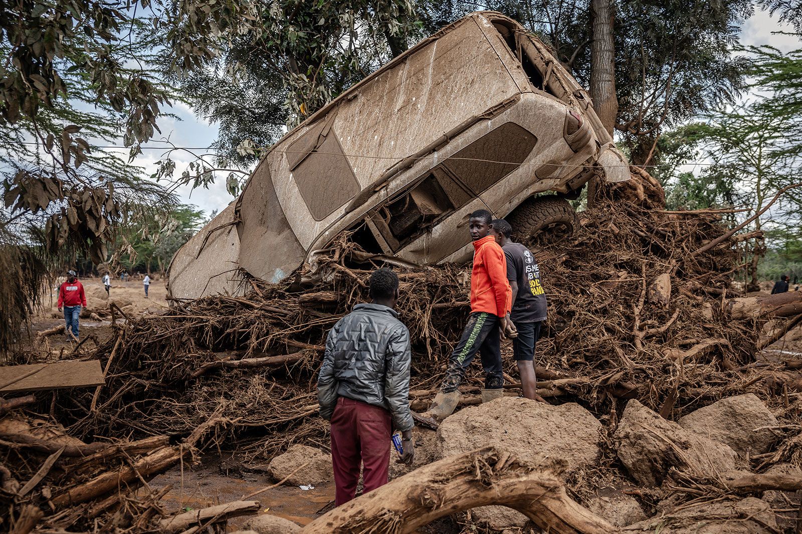 <i>Luis Tato/AFP/Getty Images/File via CNN Newsource</i><br/>Young men inspect a car destroyed by flood waters in an area heavily affected by torrential rains