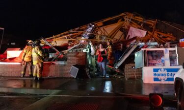 An employee emerges from the rubble of a Family Dollar destroyed by a tornado in Lake Village