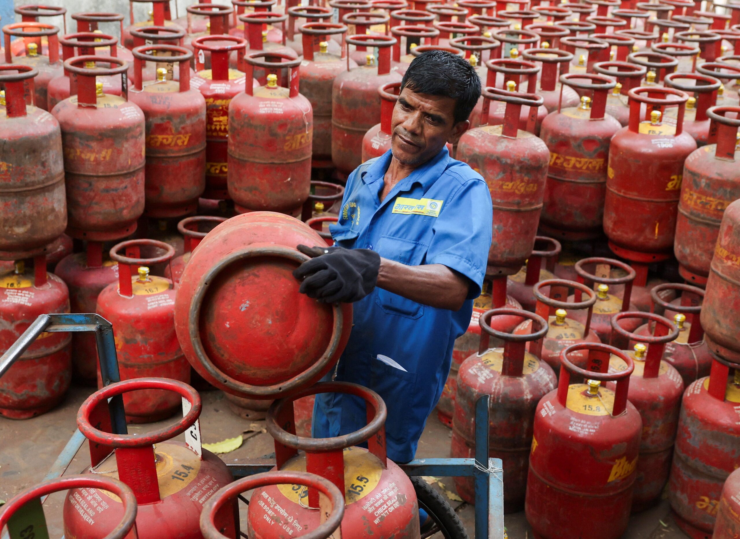 <i>Bhawika Chhabra/Reuters via CNN Newsource</i><br/>A man sits on an empty LPG cylinder as he waits outside a gas agency amid supply disruptions following the U.S.-Israeli conflict with Iran