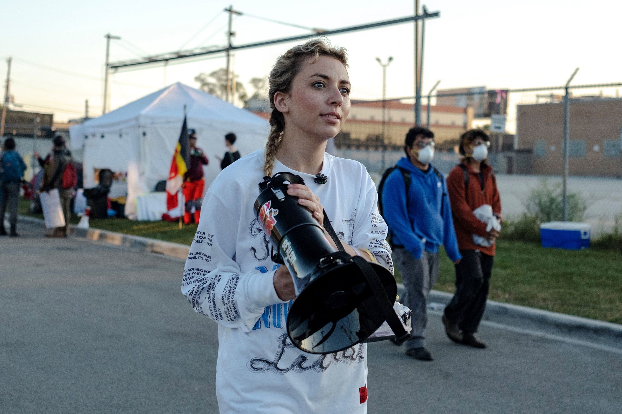 <i>Jim Vondruska/Reuters via CNN Newsource</i><br/>Democratic congressional candidate Kat Abughazaleh holds a megaphone outside of the Broadview ICE processing facility