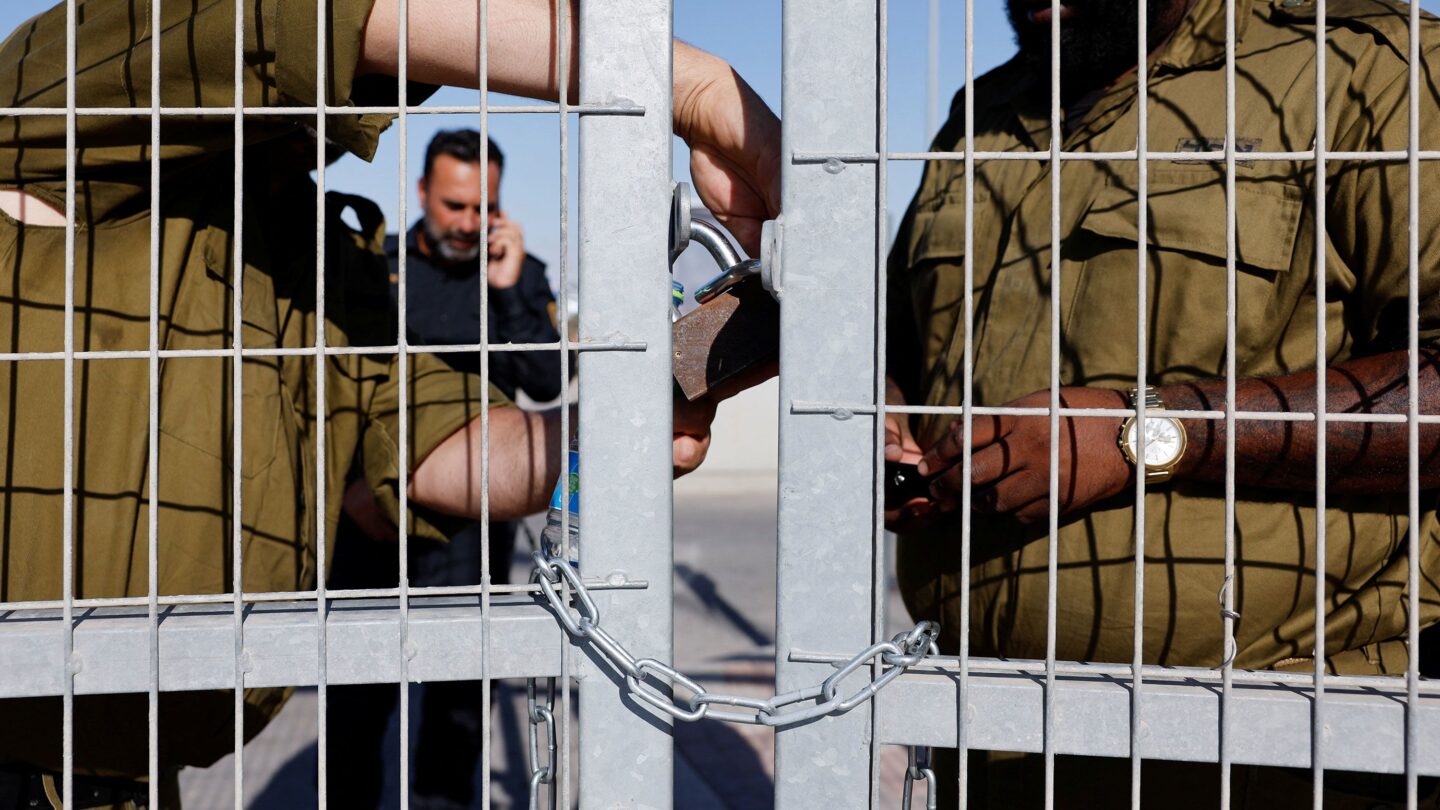 <i>Amir Cohen/Reuters via CNN Newsource</i><br/>Soldiers lock a gate from inside the Sde Teiman detention facility in July 2024.
