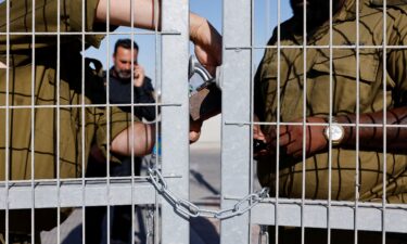 Soldiers lock a gate from inside the Sde Teiman detention facility in July 2024.