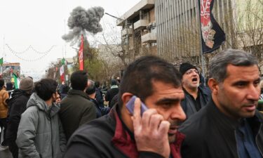 Rescue workers search for survivors in the rubble after a strike in southern Tehran