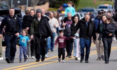 People embrace as law enforcement escort families away from the Temple Israel synagogue Thursday in West Bloomfield Township