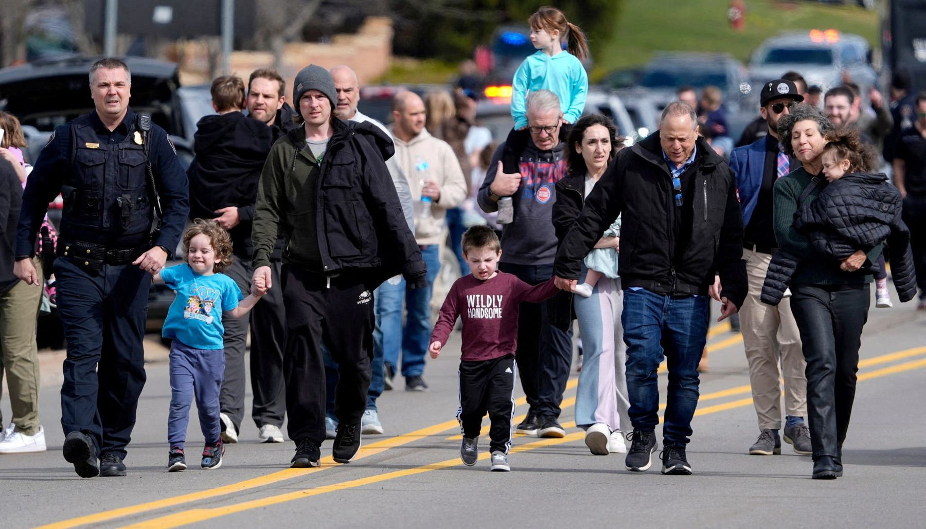 <i>Paul Sancya/AP via CNN Newsource</i><br/>People embrace as law enforcement escort families away from the Temple Israel synagogue Thursday in West Bloomfield Township