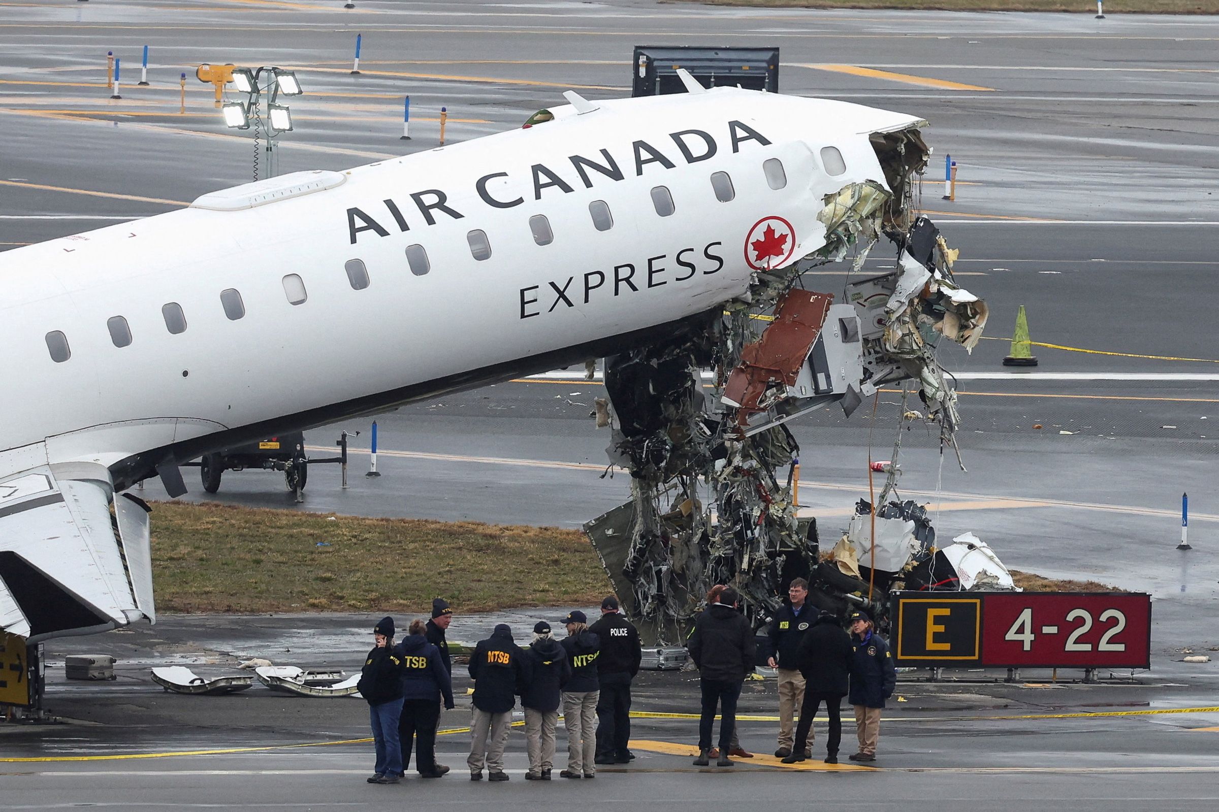 <i>Ryan Murphy/AP via CNN Newsource</i><br/>An aircraft rescue and firefighting vehicle lays on its side after colliding with an Air Canada Express regional jet landing at LaGuardia Airport